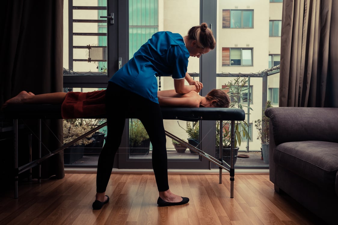 Massage Therapist Treating Patient at Home